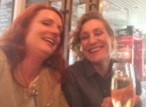 Malin och Anita dricker champagne och skrattar.